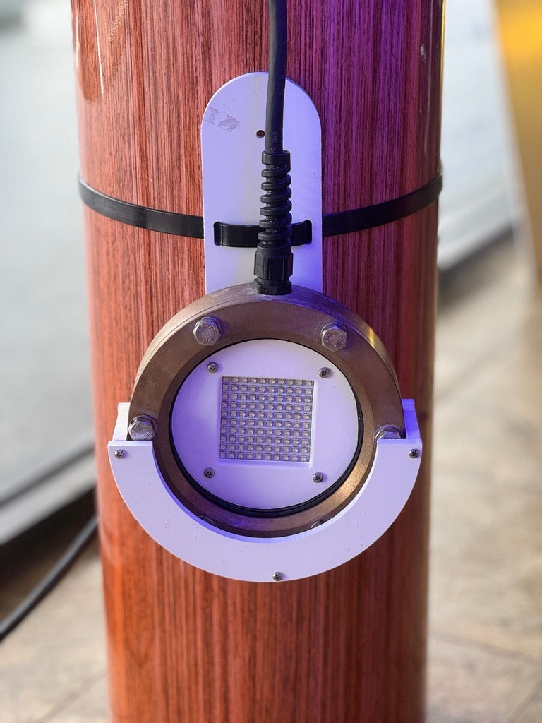 DV59 LED dock light shown with PVC bracket installed on wood piling out of water 


